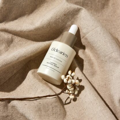 White serum bottle with a branch on cloth