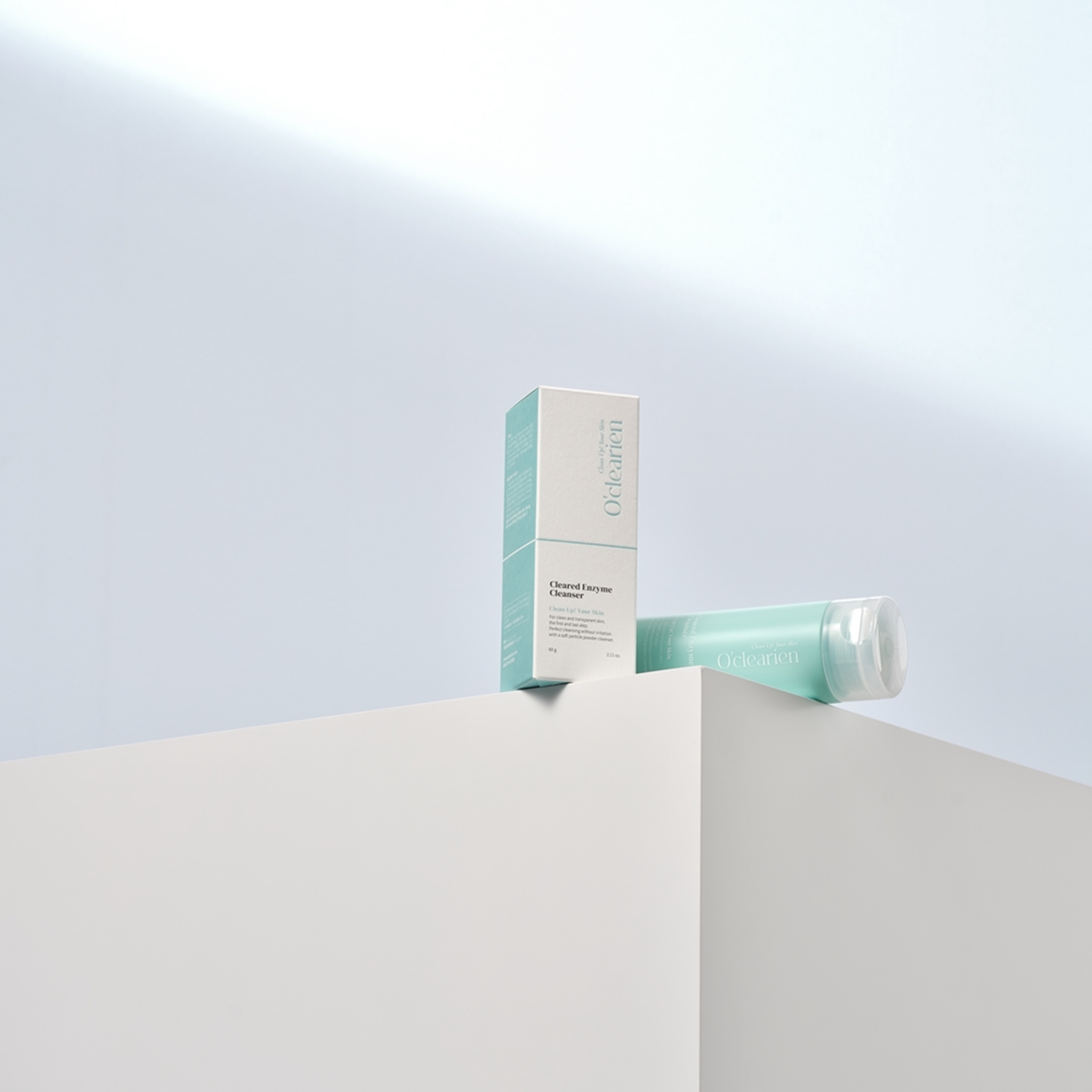 one box of cleanser and one bottle of cleanser are on the edge of white box